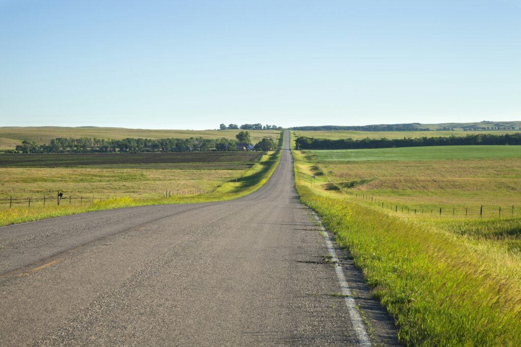 Country road winding through farmland in the morning light during summer in Rapid City, SD, epitomizing the idyllic rural charm and Clear to Launch Dental Marketing' effective dental marketing strategies tailored for Rapid City dental practices.