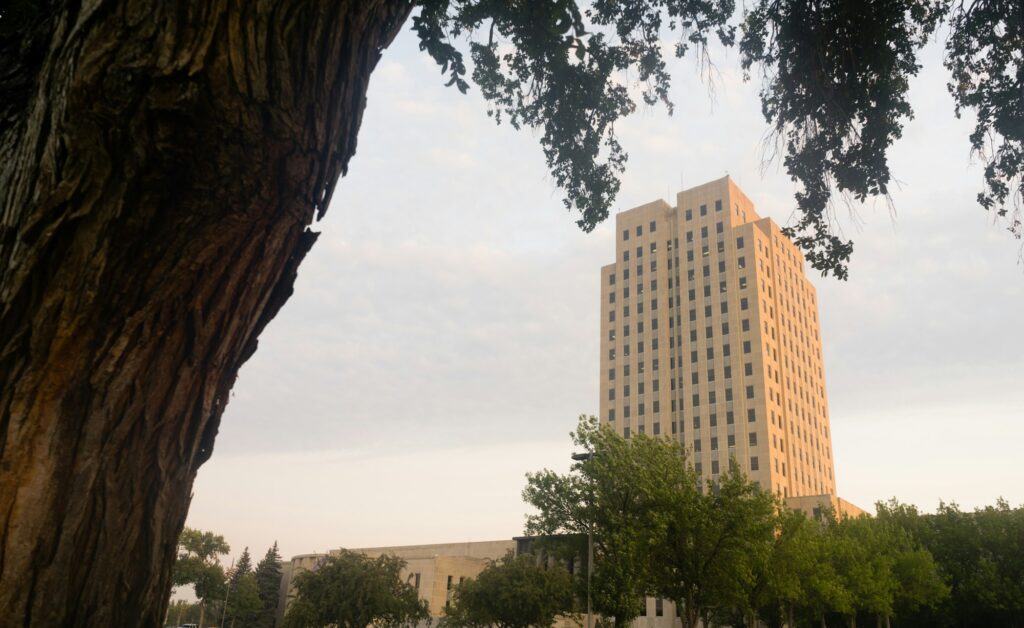 Large oak tree stands near the North Dakota Capitol building in Bismarck, ND, symbolizing strength and stability amidst the city's historic architecture and Clear to Launch Dental Marketing' strategic dental marketing initiatives tailored for Bismarck dental practices.
