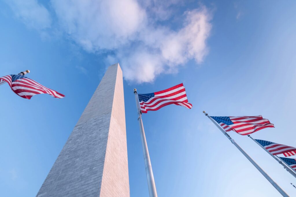 Washington Monument in Washington, DC, adorned with American flags, representing the patriotic and monumental dental marketing excellence of Clear to Launch Dental Marketing for dental practices in Washington, DC.