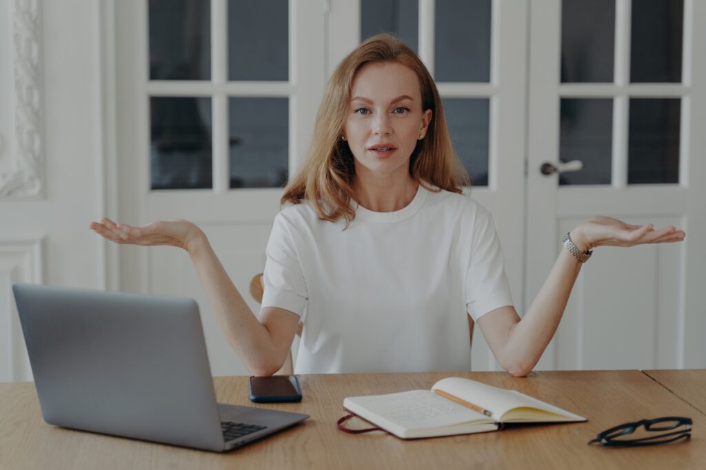 Confused woman at laptop weighing options, symbolizing how to choose the right healthcare marketing agency with Clear to Launch Healthcare Marketing