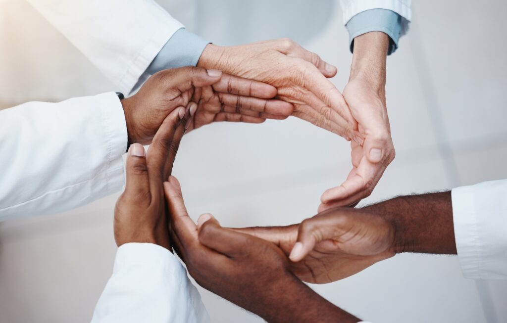 Diverse hands forming a circle symbolizing unity and trust, representing Clear to Launch Healthcare Marketing’s focus on building patient trust through testimonials and reviews