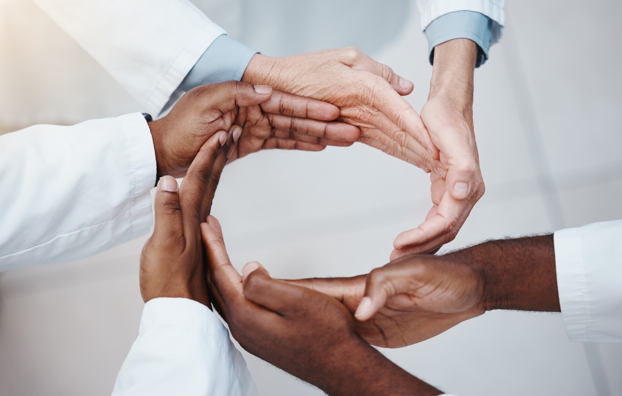 Diverse hands forming a circle symbolizing unity and trust, representing Clear to Launch Healthcare Marketing’s focus on building patient trust through testimonials and reviews