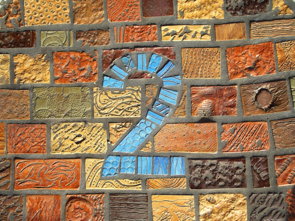 Blue number 2 on a colorful mosaic wall symbolizing Step 2 in Clear to Launch Healthcare Marketing’s modern dental marketing strategy