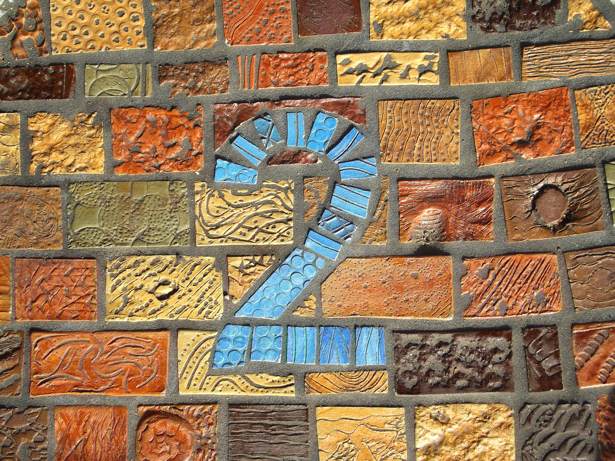 Blue number 2 on a colorful mosaic wall symbolizing Step 2 in Clear to Launch Healthcare Marketing’s modern dental marketing strategy