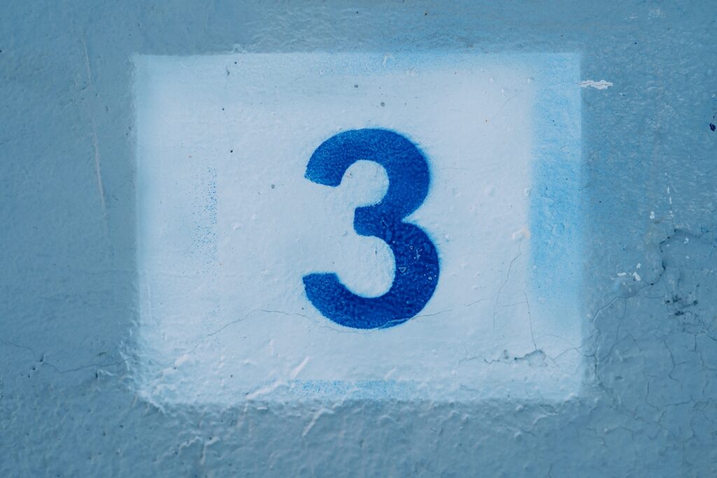 Number three drawn on a blue wall in a white rectangle
