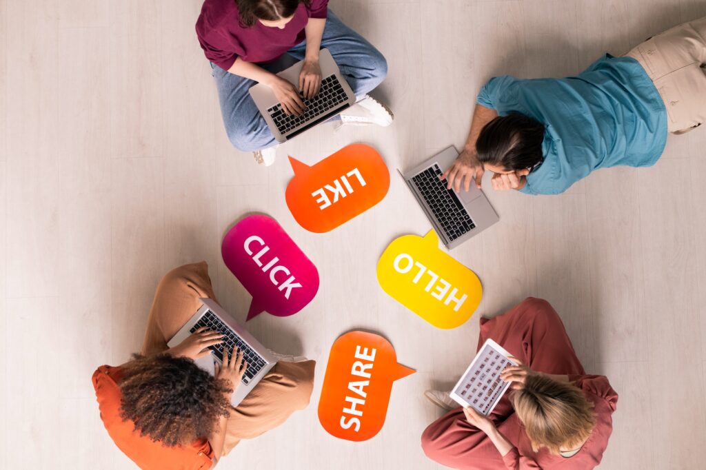 Group of people on laptops surrounded by social media icons, representing Clear to Launch Healthcare Marketing’s guide to creating engaging social media content