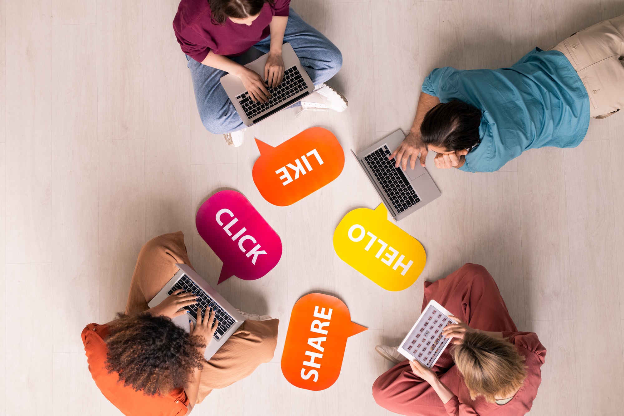 Group of people on laptops surrounded by social media icons, representing Clear to Launch Healthcare Marketing’s guide to creating engaging social media content