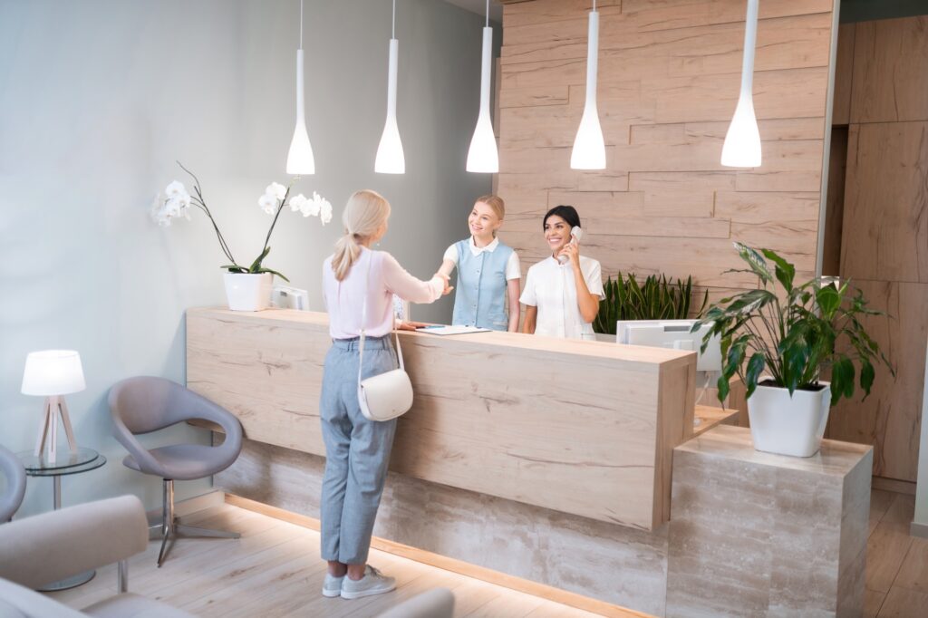 Patient checking in at a sleek dental office front desk, representing the importance of strong dental branding and a polished first impression