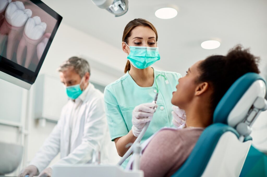 Dental team treating a patient in a modern office, symbolizing increased visibility from Google Ads for dentists
