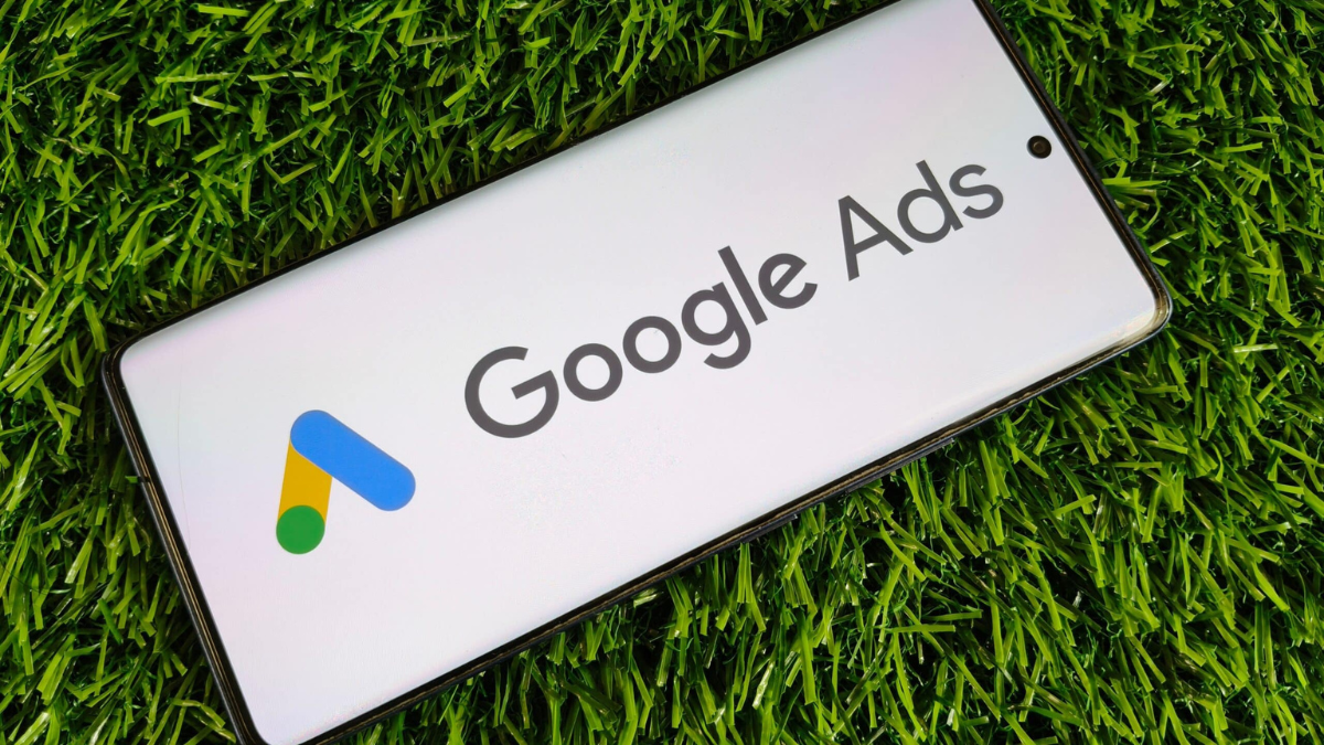 google ads for dentist displayed on phone in green grass - clear to launch